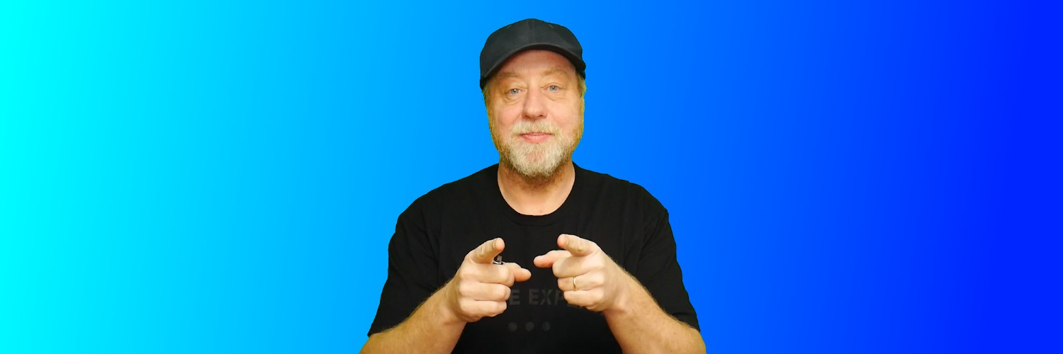 Gary Sims, the face behind Gary Explains, pointing towards the camera against a blue background